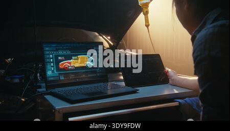 Female Technician Analyzing Vehicle Digital Twin on Laptop, With 3D Models Showing Internal Component Status. Simultaneously, Woman Interacts With Tablet to Track Performance Curves and System Logs. Stock Photo