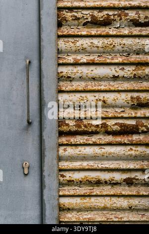 Rusty old shutter and gray door with lock Stock Photo