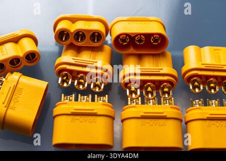 Vibrant yellow MR60 power connectors, male and female, for motor wiring. Shiny gold-plated contacts detailed in a close-up shot. Essential electrical Stock Photo
