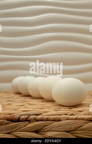 Minimal Easter still life with white eggs arranged diagonal on textured neutral background. Natural spring composition with copy space suitable for gr Stock Photo