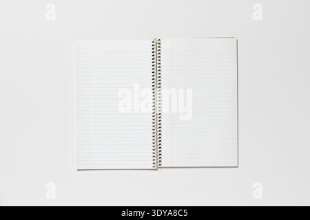 Open spiral notepad on a white background. The page is blank. Stock Photo