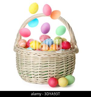 Easter eggs falling into basket on white background Stock Photo