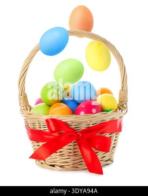 Easter eggs falling into basket on white background Stock Photo