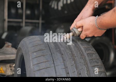 Working on tire repair in a busy garage Stock Photo