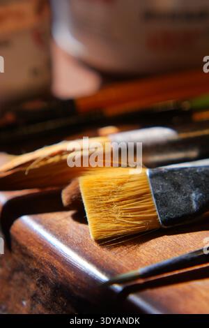 Brushes and tools on wooden surface in art space Stock Photo