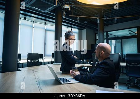 Diverse professionals collaborating in modern office boardroom Stock Photo