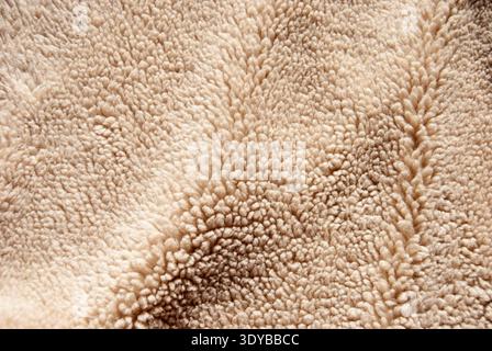 A close-up of brown fur texture. Sheep faux fur texture. Stock Photo