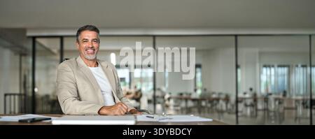 Happy middle aged business man ceo executive sitting in office. Portrait Stock Photo