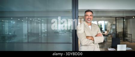 Portrait of confident happy middle aged business man looking away in office. Stock Photo