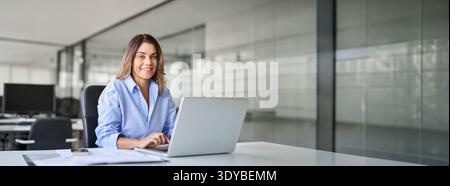 Happy mature professional business woman with laptop in office, portrait. Stock Photo