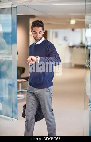 Businessman, checking and watch with time in office for schedule meeting or project deadline. Man, employee or leaving with wristwatch for appointment Stock Photo