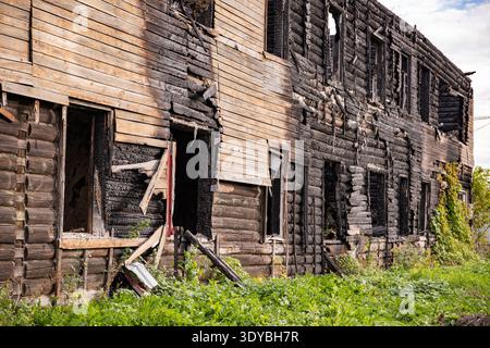 Abandoned log house aftermath showing extensive fire damage and destruction Stock Photo