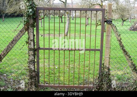 strong tall gate around a fruit garden in France Stock Photo