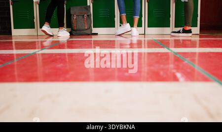 Feet, students or teenager by locker in high school, scholarship chat or together for education support. Academy floor, kids or friends with Stock Photo