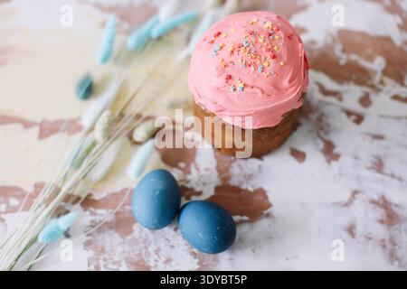 Easter Cake and Pastries, Blue Eggs and willow branches.Traditional Easter powdered sugar pastries, blue marbled eggs, delicate flowers, symbolizing Stock Photo