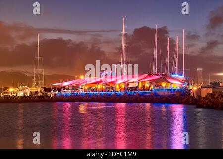 Night Marina Restaurant In Ibiza With Colourful Lights, Yachts and Waterfront Reflections at Dusk Stock Photo