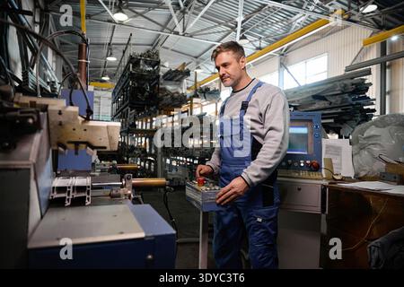 Professional production workers in coverall working with different PVC windows Stock Photo