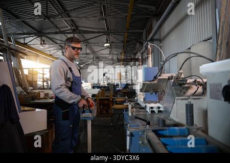 Professional production workers in coverall working with different PVC windows Stock Photo