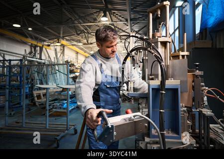 Professional production workers in coverall working with different PVC windows Stock Photo