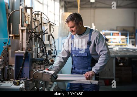 Professional production workers in coverall working with different PVC windows Stock Photo