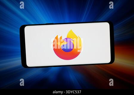In this photo illustration, the logo of open-source web browser Mozilla Firefox seen displayed on a smartphone in front of an abstract background on computer screen. Stock Photo