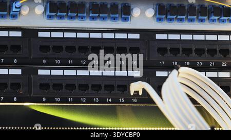 Network cables connecting to patch panel in data center for internet communication Stock Photo