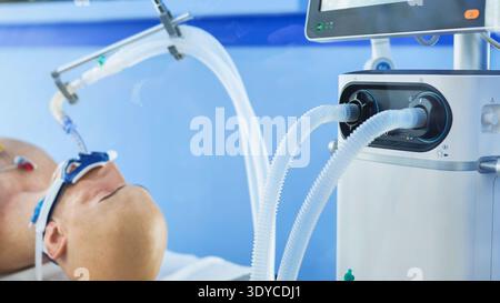 Patient receiving respiratory support in intensive care unit connected to ventilator Stock Photo