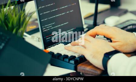 Programmer typing keyboard laptop screen source code. Software development workflow computer workstation coding environment. Digital engineering proce Stock Photo
