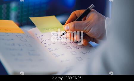 Checklist notebook task completion marking done list. Hand marking completed tasks checklist productivity planning workflow organization concept. Pers Stock Photo