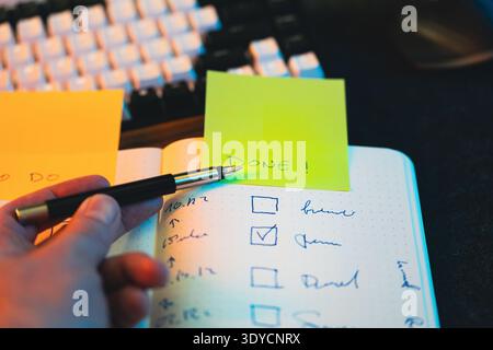 Checklist notebook completed task sticky note DONE. Hand pointing finished task checkmark productivity progress tracking organization workflow plannin Stock Photo