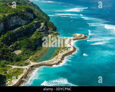 Breathtaking aerial view of tropical coastline with steep green cliffs and rolling waves Stock Photo