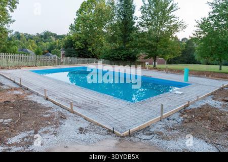 Blue fiberglass swimming pool set in place with framing and wire mesh ready for pouring concrete deck Stock Photo