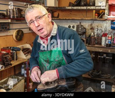 Cobbler Richard Deverrill at shoe repair shop in Pangbourne Stock Photo