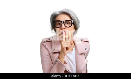 Mature woman signaling silence with finger on lips Stock Photo