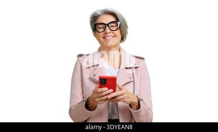 Senior woman smiling at camera, holding a red smartphone Stock Photo