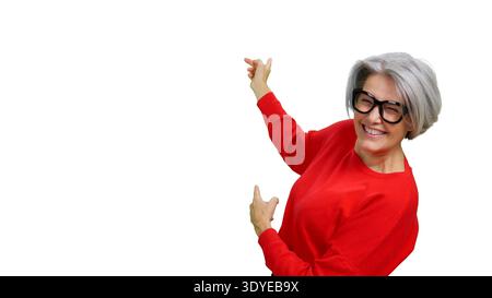 Senior woman smiling pointing up and away with both hands Stock Photo