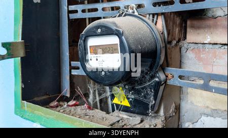 An old electric meter displaying the electricity consumed in an old industrial building. Part of an electrical panel. Measuring used electricity in kW Stock Photo