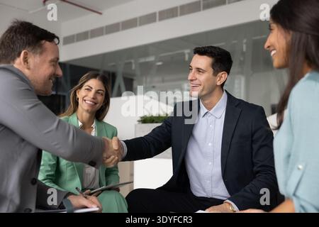 Two diverse male colleagues handshaking on staff meeting in office Stock Photo