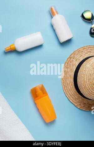beach bag with beach accessories on a colored background top view. Sunscreen, towel, glasses, hat. Stock Photo