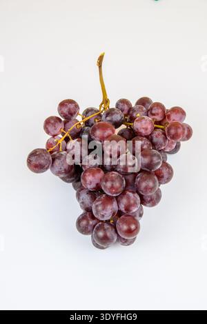 Single bunch of red grapes isolated on a clean white background, minimalist fruit image for harvest, vineyard, fresh produce and wine related concepts Stock Photo