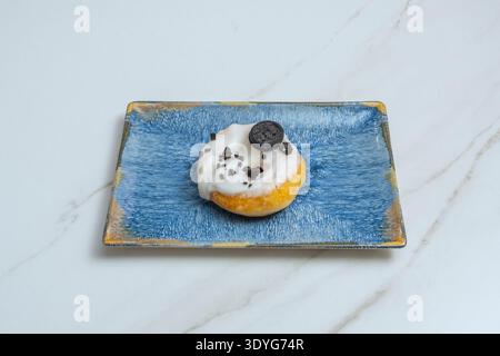 A still life for chocolate lovers, featuring a donut dipped in dark chocolate, another with white chocolate chips, and another filled with pure cocoa Stock Photo
