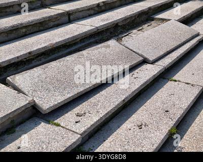 Photo of a stone granite staircase with broken steps. Stock Photo