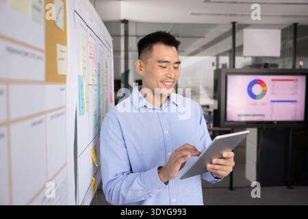 Smart young male professional using digital tablet in modern office Stock Photo