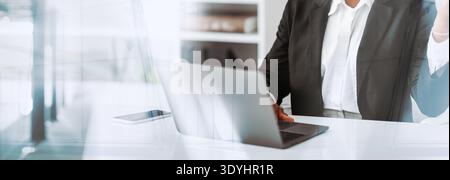Black Businesswoman Experiencing Stress While Working in Office and Looking at Laptop Screen Stock Photo