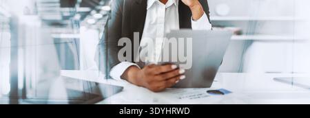 Confident Black Woman Engages in Business Work With Digital Tablet in Modern Office Setting Stock Photo