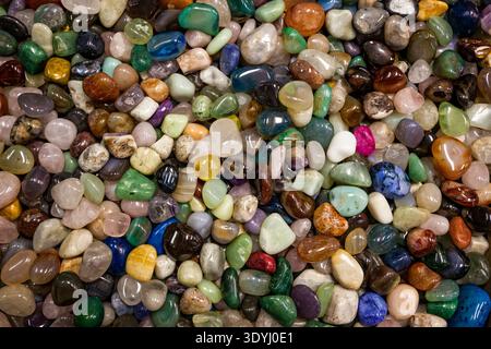 Close view of a large collection of colorful polished stones filling the frame, showing smooth textures and natural patterns. Stock Photo