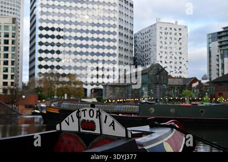 Urban Birmingham canal featuring narrowboats, Victoria boat, historic building and striking patterned skyscrapers Stock Photo