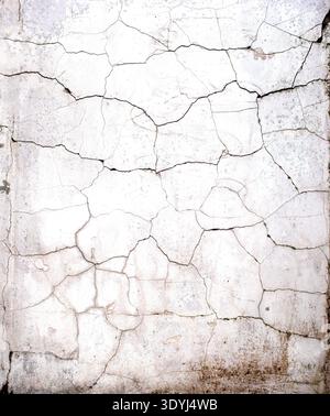 Deep network of cracks on old white concrete wall texture closeup Stock Photo