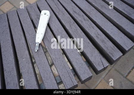 Cross cutting knife. Internet Cable laying tool LSA-Plus for installing wires at sockets, patch panels and plinths on wooden backgrounds Stock Photo