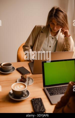 women working remotely together in cozy cafe workspace Stock Photo